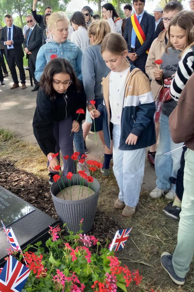Des enfants déposent des fleurs