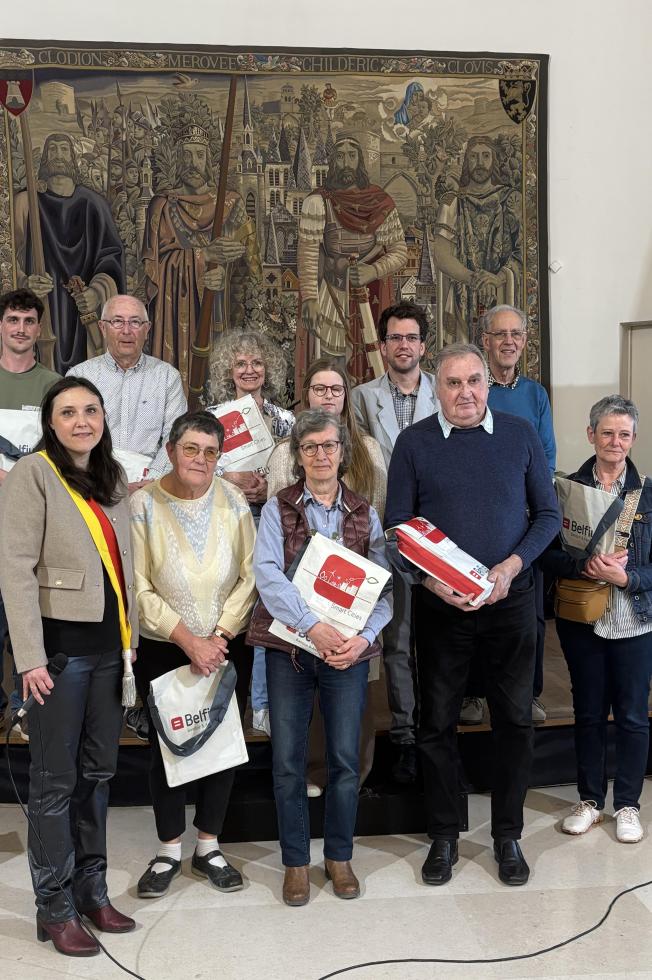 Un groupe d’adultes pose avec des récompenses lors de la remise des prix des Olympiades d’orthographe
